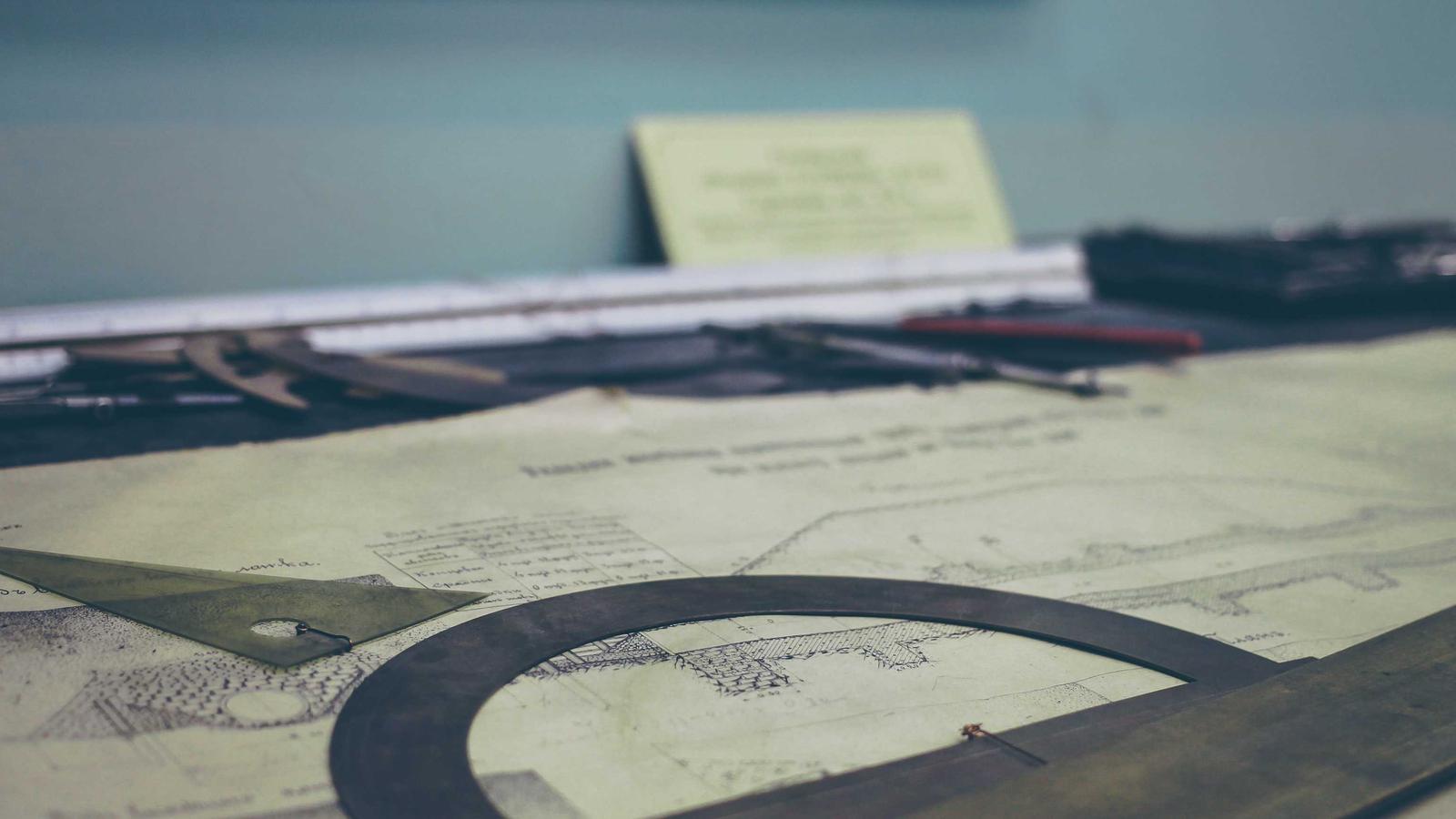 Drafting table with maps and measuring instruments