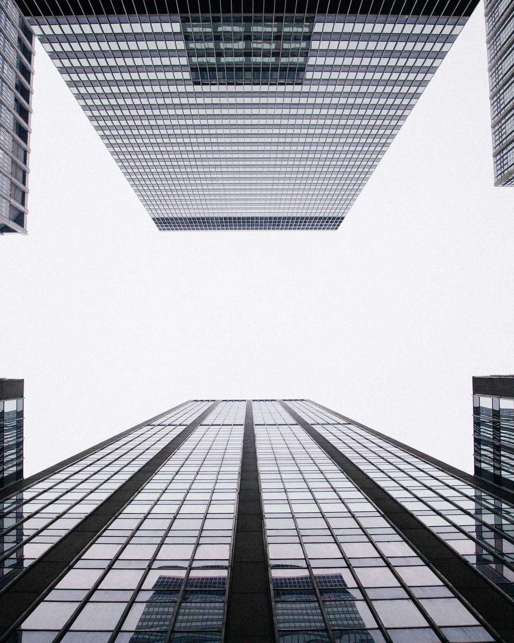 Glass office towers seen from below, converging against the sky