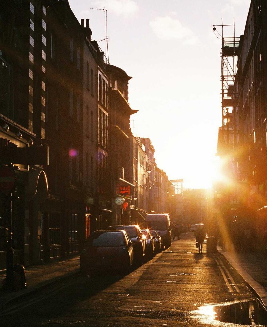 City street at dusk lit by low golden sunlight